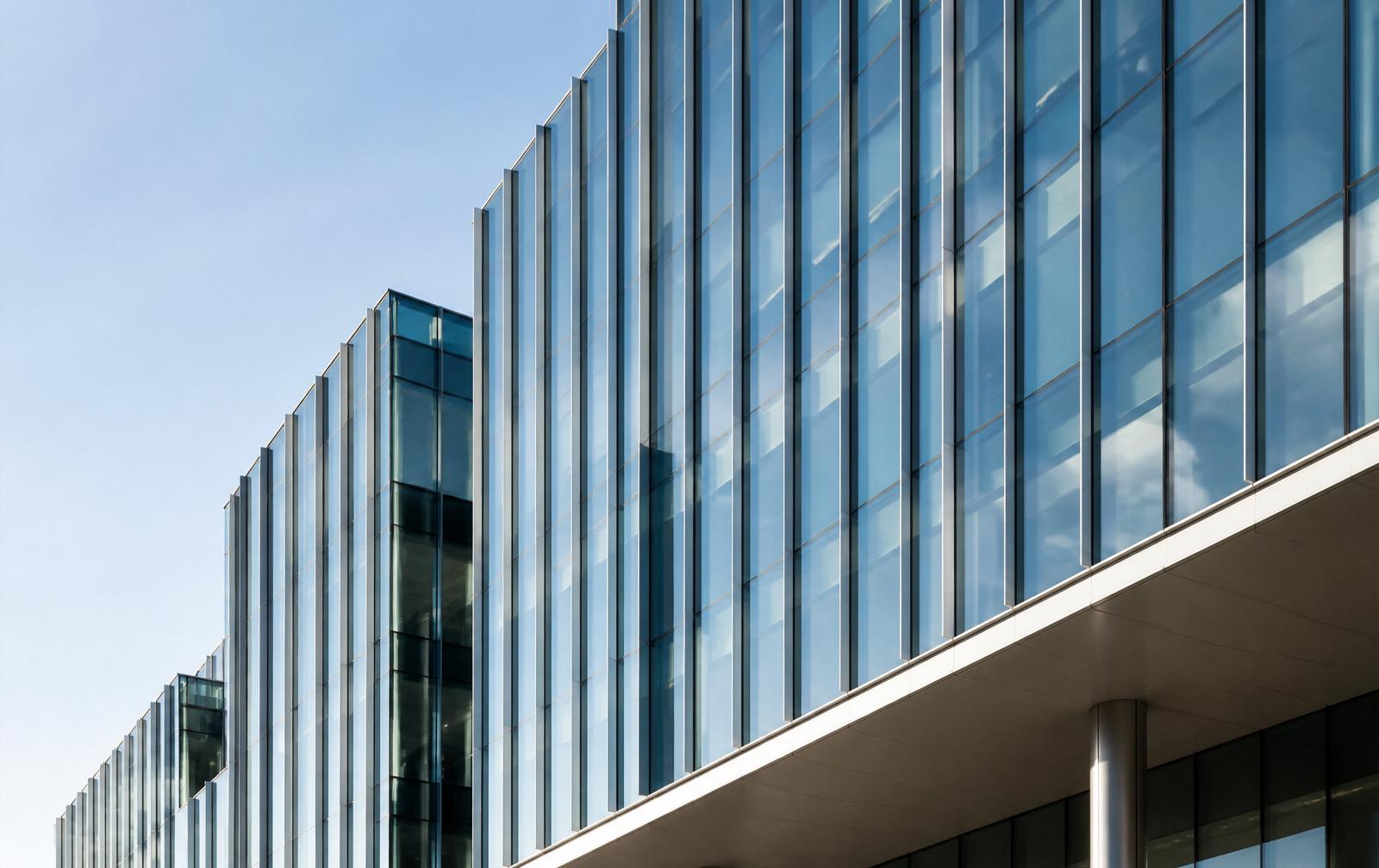 Glass office tower under bright sky